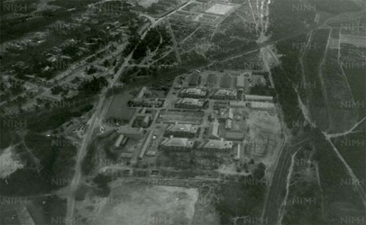 <p>Luchtfoto uit 1962 van de Elias Beekmankazerne. Inmiddels is het kazerneterrein uitgebreid met loodsgebouwen en het wachtgebouw, bureelgebouw en kantinegebouw (links op de foto) (beeldbank NIMH).  </p>
